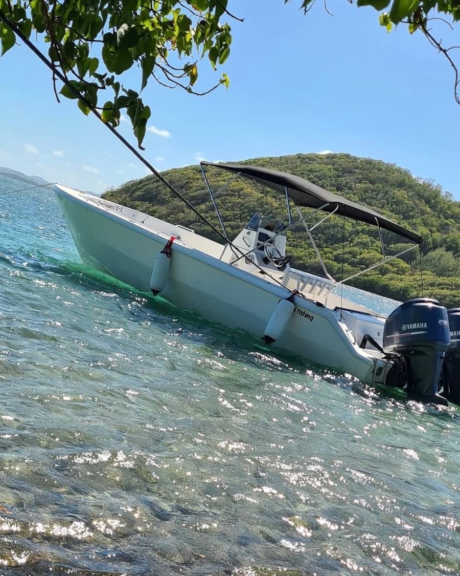 Le bateau au mouillage contre un îlet, dans une eau claire