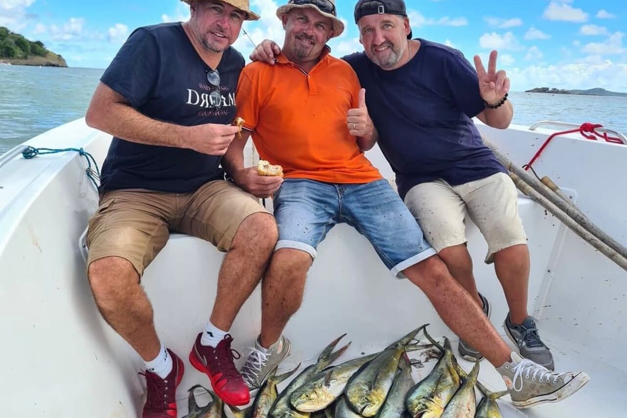 Three passengers on the chartered boat with a catch of mahi-mahi